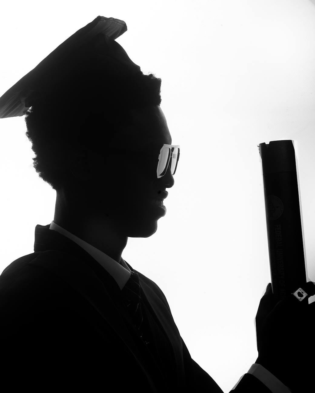 black and white silhouette of graduate holding diploma